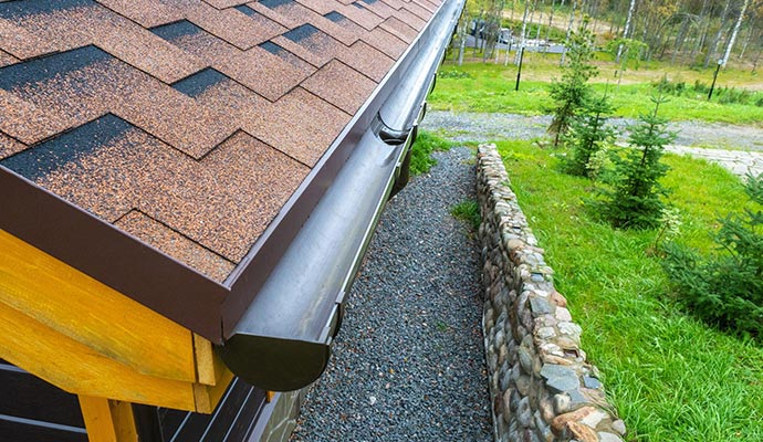 Clean and brightened gutter installed along a roof edge with clear drainage and restored exterior appearance