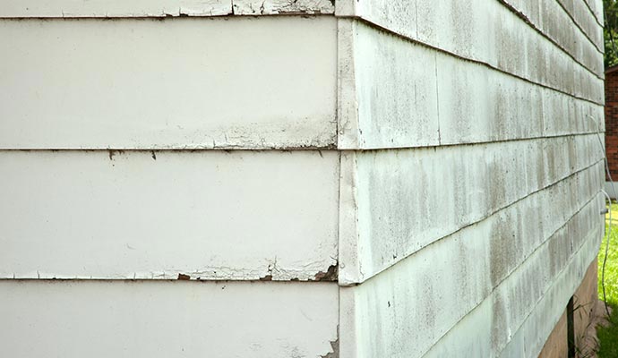 Exterior siding showing moisture damage and staining caused by improper drainage from clogged gutters.