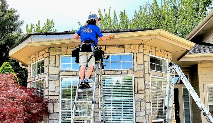 Technician installing leaf guards on residential rain gutters
