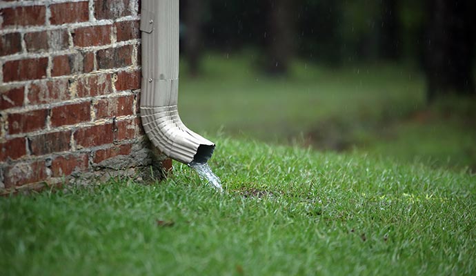 Rainwater flowing out of a gutter downspout.