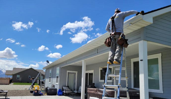 Installer working on high-quality rain gutters on a covered patio roof