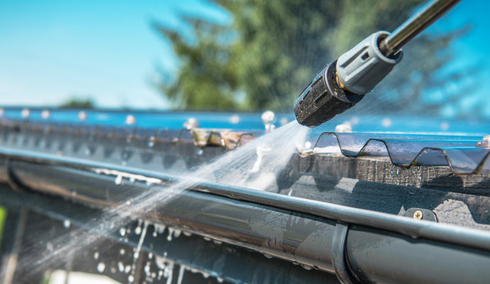 Professional worker cleaning gutter