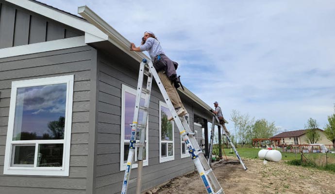 Professional installation of durable seamless gutters on a residential home