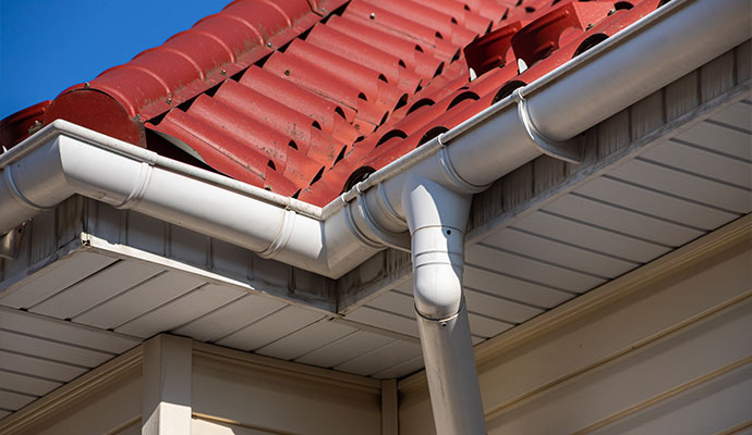 Vinyl gutter and downspout installed roof on a residential home