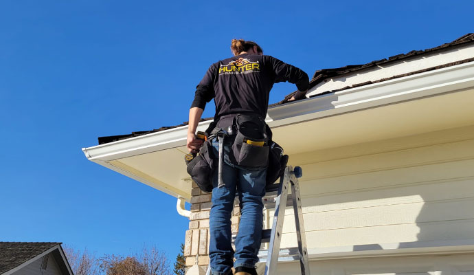 Professional gutter inspection service on a roof gutter of a house