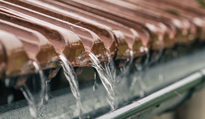 Rainwater flowing through a roof gutter system