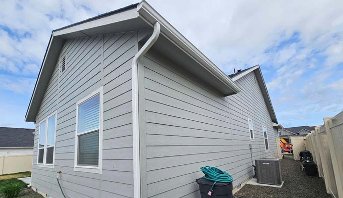 Residential house with clean downspout and installed seamless gutter system