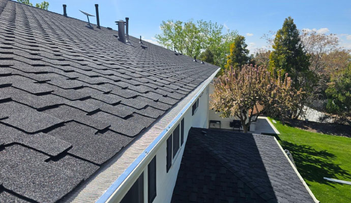 Asphalt shingle roof with gutter guard along the roof edge